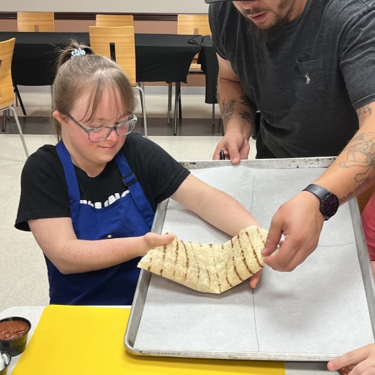 Cooking student placing tortilla on pan